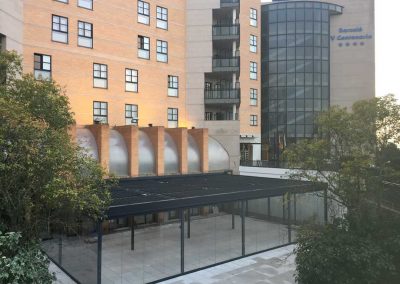 Pergola bioclimatica y cortinas de cristal en hotel